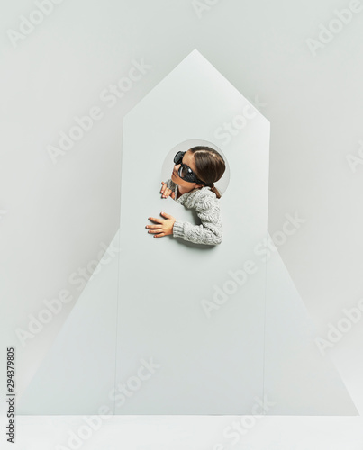 Fotografie Playful child in rocket in studio shot