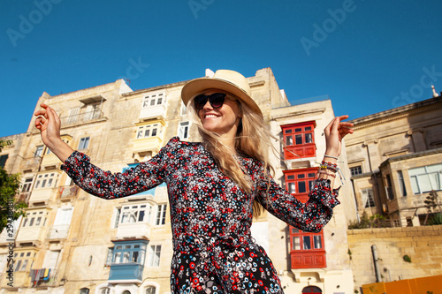 Happy young carefree woman enjoying sightseeing in Valletta