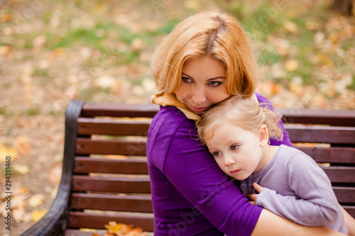 Young mother and her toddler girl have fun in autumn
