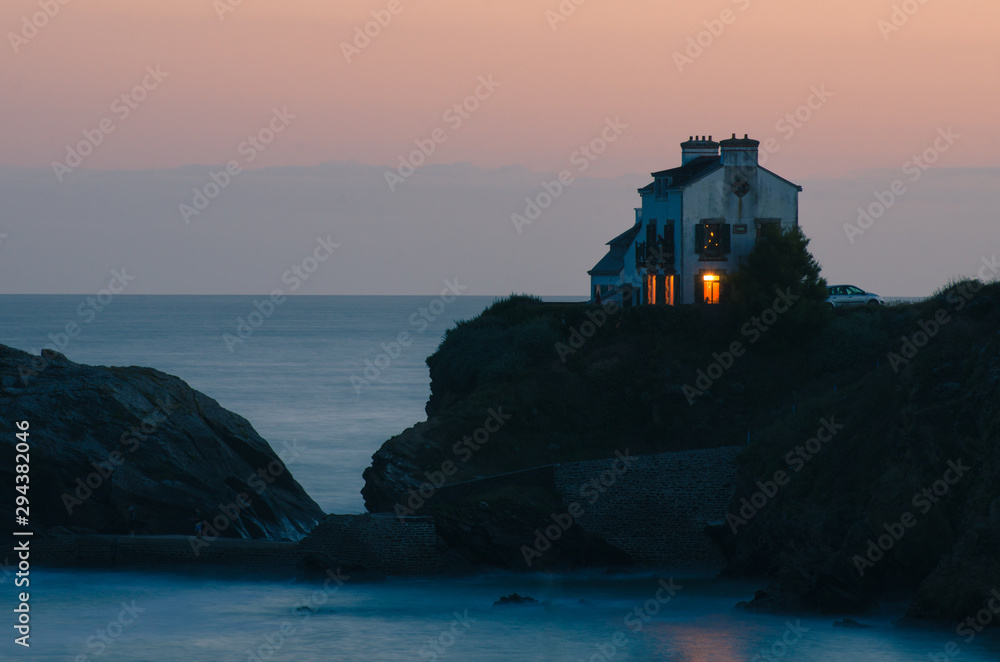 une maison seule au crépuscule sur le bord de la mer en Bretagne