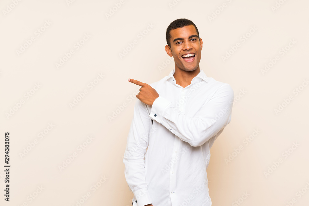 Young handsome brunette man over isolated background surprised and pointing side Young handsome brunette man over isolated background surprised and pointing side