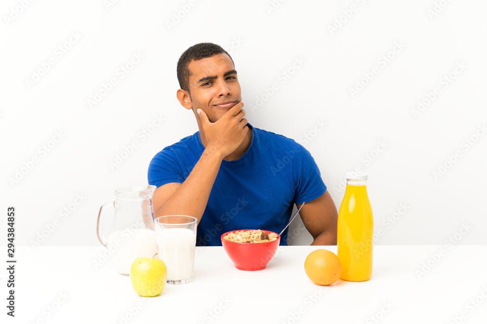 Young man having breakfast in a table thinking an idea Young man having breakfast in a table thinking an idea