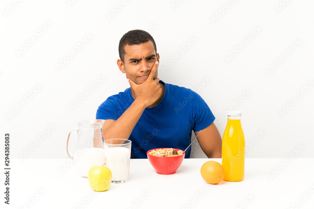 Young man having breakfast in a table thinking an idea Young man having breakfast in a table thinking an idea