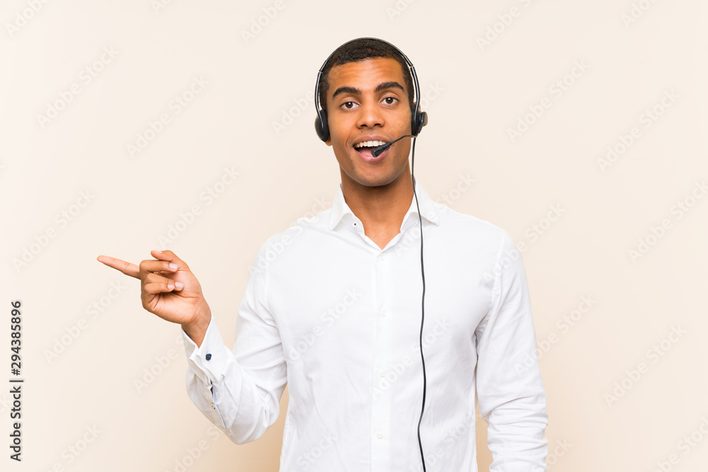 Young brunette man working with a headset surprised and pointing finger to the side Young brunette man working with a headset surprised and pointing finger to the side