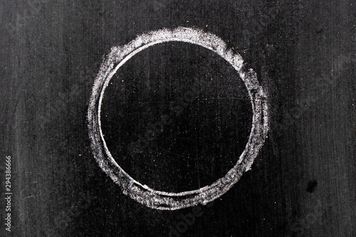 White chalk hand drawing in circle or round shape on black board background