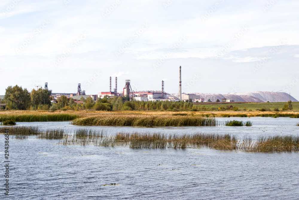 Industry and wildlife. Mining industry. The combination of nature and technology. Ore mining. The extraction of potassium salt. Belarus. Salihorsk. The mine on the background of the river.