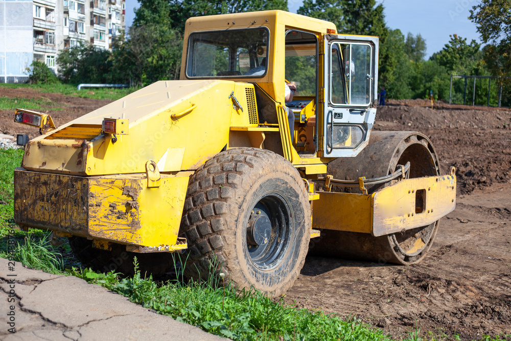 Bulldozer at a construction site. Heavy machinery performs construction work. A bulldozer levels the ground. The car is diesel powered.