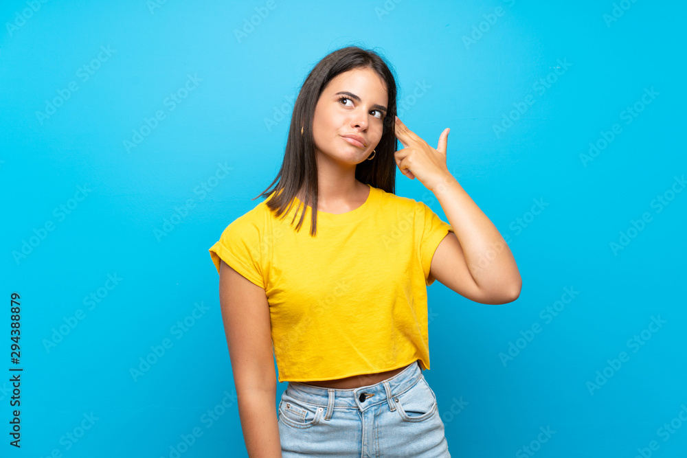 Young girl over isolated blue background with problems making suicide gesture Young girl over isolated blue background with problems making suicide gesture
