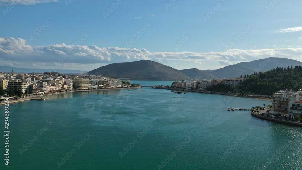 Aerial drone photo of famous seaside town of Halkida or Chalkida with beautiful clouds and deep blue sky featuring old bridge connecting Evia island with mainland Greece