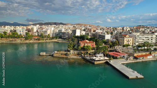 Aerial drone photo of famous seaside town of Halkida or Chalkida with beautiful clouds and deep blue sky featuring old bridge connecting Evia island with mainland Greece © aerial-drone