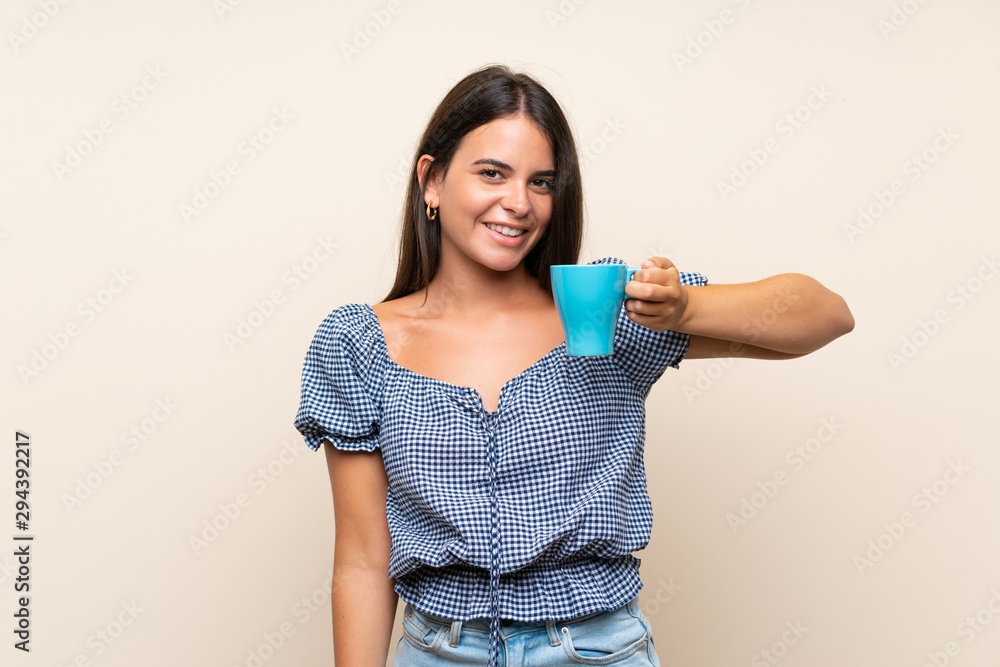 Young girl over isolated background holding hot cup of coffee Young girl over isolated background holding hot cup of coffee