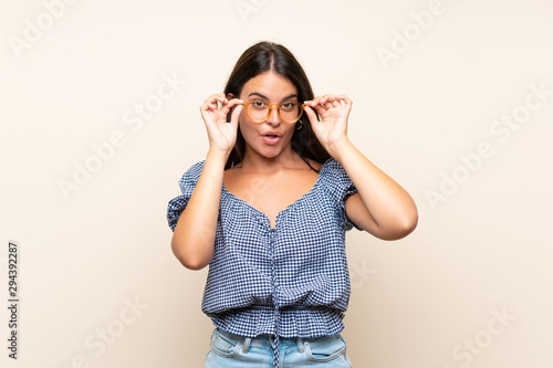 Young girl over isolated background with glasses © luismolinero