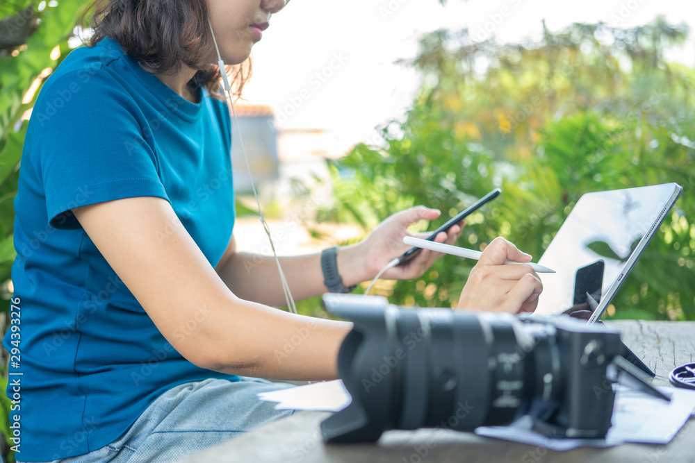 Photographer sitting and editing photos using a tablet. Portable size, smart features In a coffee shop or café Photographer sitting and editing photos using a tablet. Portable size, smart features In a coffee shop or café