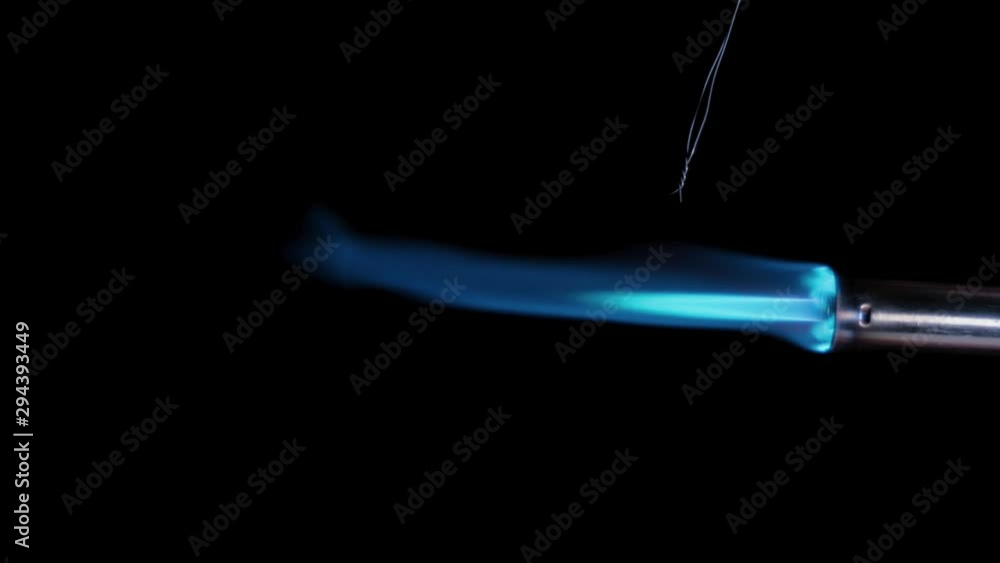 Butane gas burner flame burning from nozzle against black background. Welding tool with burner flame. Blue and Orange Flame from a butane blow torch. Closeup of butane burner.
