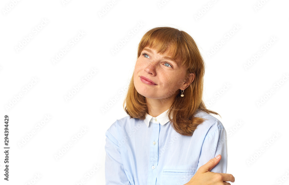 Headshot of redheaded girl with freckles and bang hairstyle dressed in blue shirt and looking upwards as if dreaming about something pleasant Headshot of redheaded girl with freckles and bang hairstyle dressed in blue shirt and looking upwards as if dreaming about something pleasant