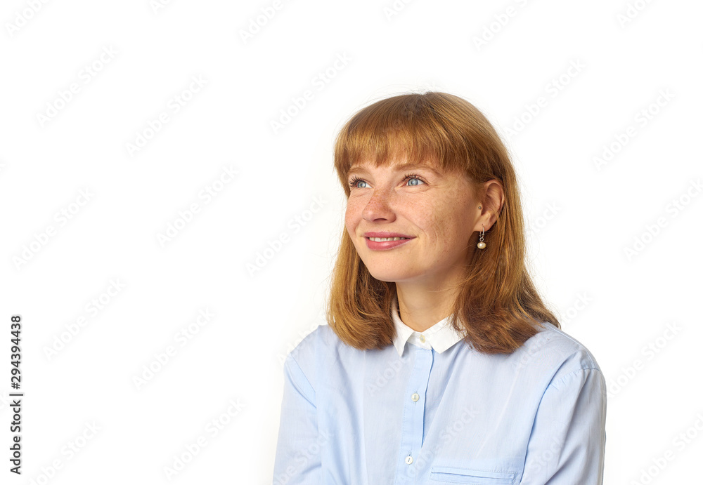 Headshot of redheaded girl with freckles and bang hairstyle dressed in blue shirt and looking upwards as if dreaming about something pleasant Headshot of redheaded girl with freckles and bang hairstyle dressed in blue shirt and looking upwards as if dreaming about something pleasant