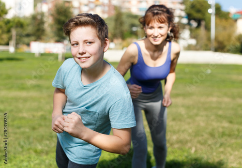 Woman and boy running outdoors