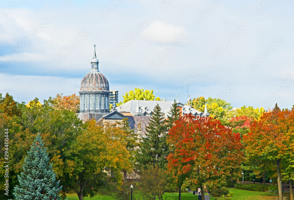 Obraz premium The dome of the Ursuline Convent in Trois Rivieres, Quebec, Canada, rises above trees marked with their fall colors