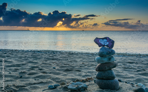First love  a pile of stones with the inscription on the beach at sunrise