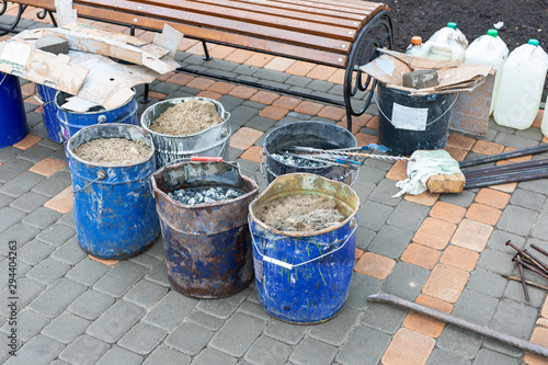 Tools for repairing sidewalk, bucket of sand, rubble on city street. Road repair, building materials. construction work © Olya