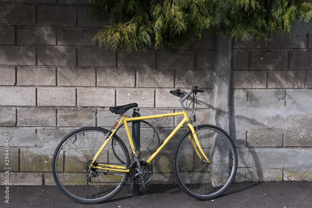 un vélo jaune posé contre un mur
