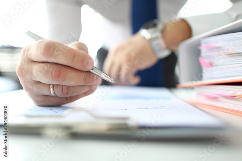 Focus on banking business or financial analyst hands pointing at business document with metallic writing pen in modern office. Businessman analyze marketing data. Audit concept