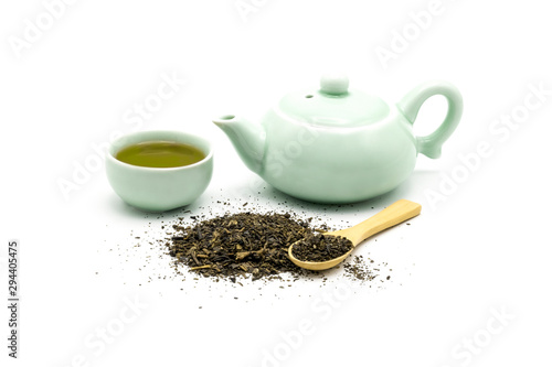 Green tea set with dry green leaves and wooden spoon isolated on white background.