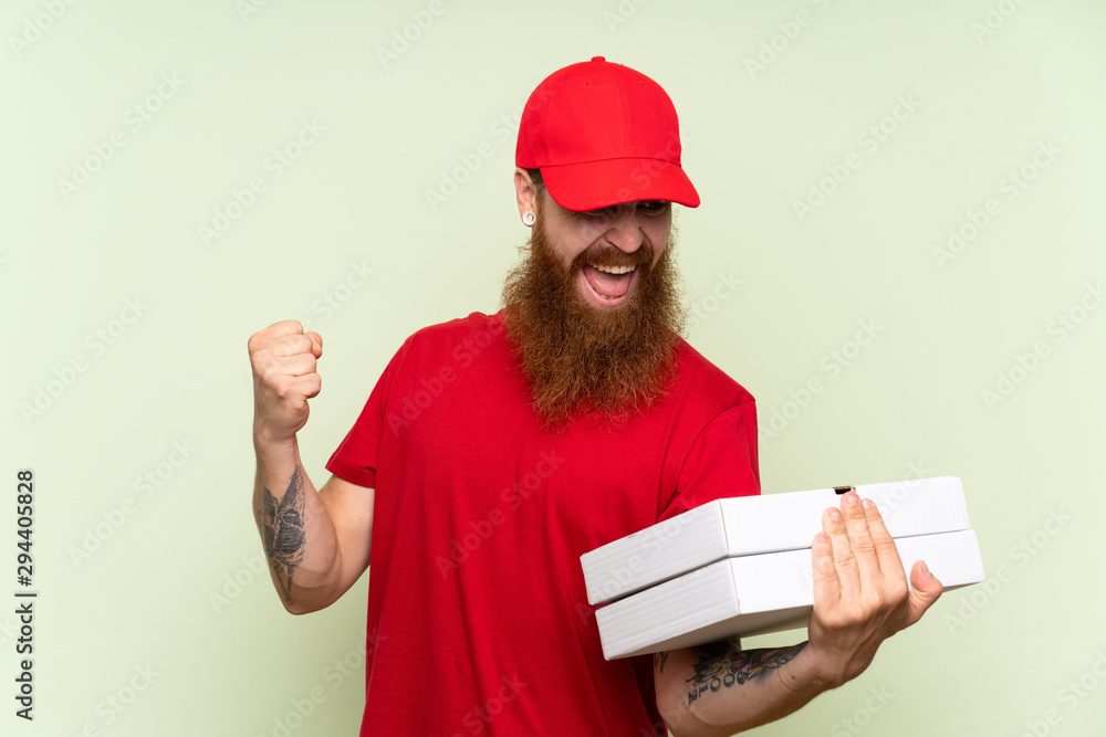 Delivery man with long beard over isolated green background celebrating a victory Delivery man with long beard over isolated green background celebrating a victory