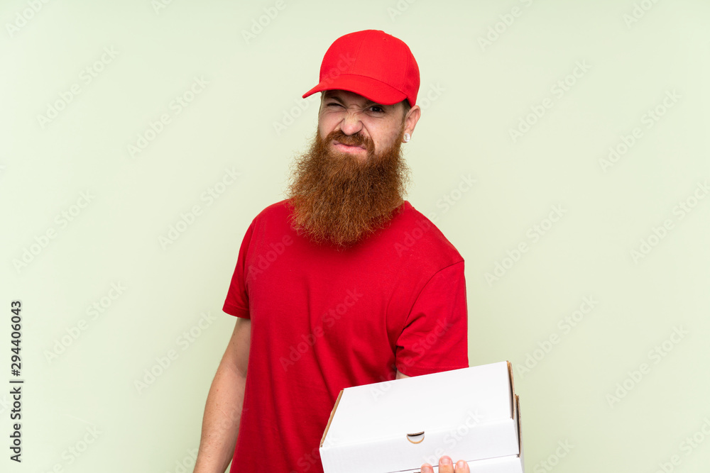 Delivery man with long beard over isolated green background with sad expression Delivery man with long beard over isolated green background with sad expression