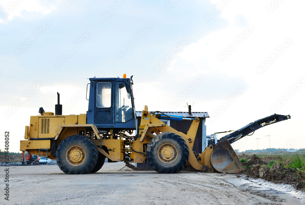 Wheel loader bulldozer with bucket on a construction site Wheel loader bulldozer with bucket on a construction site