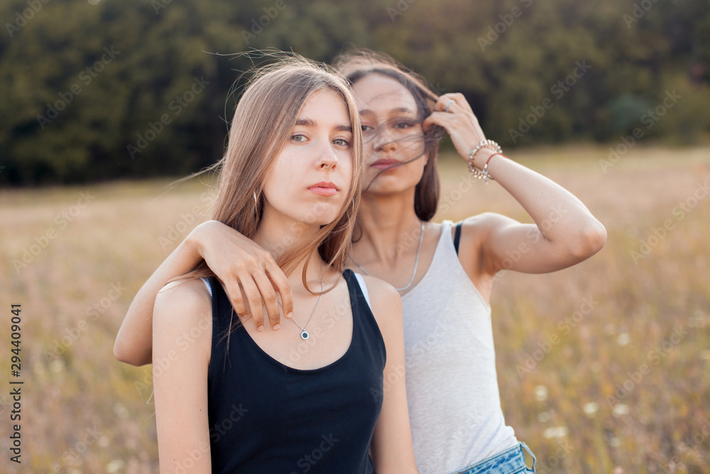 Two attractive girls spend time together outdoors. Two attractive girls spend time together outdoors.