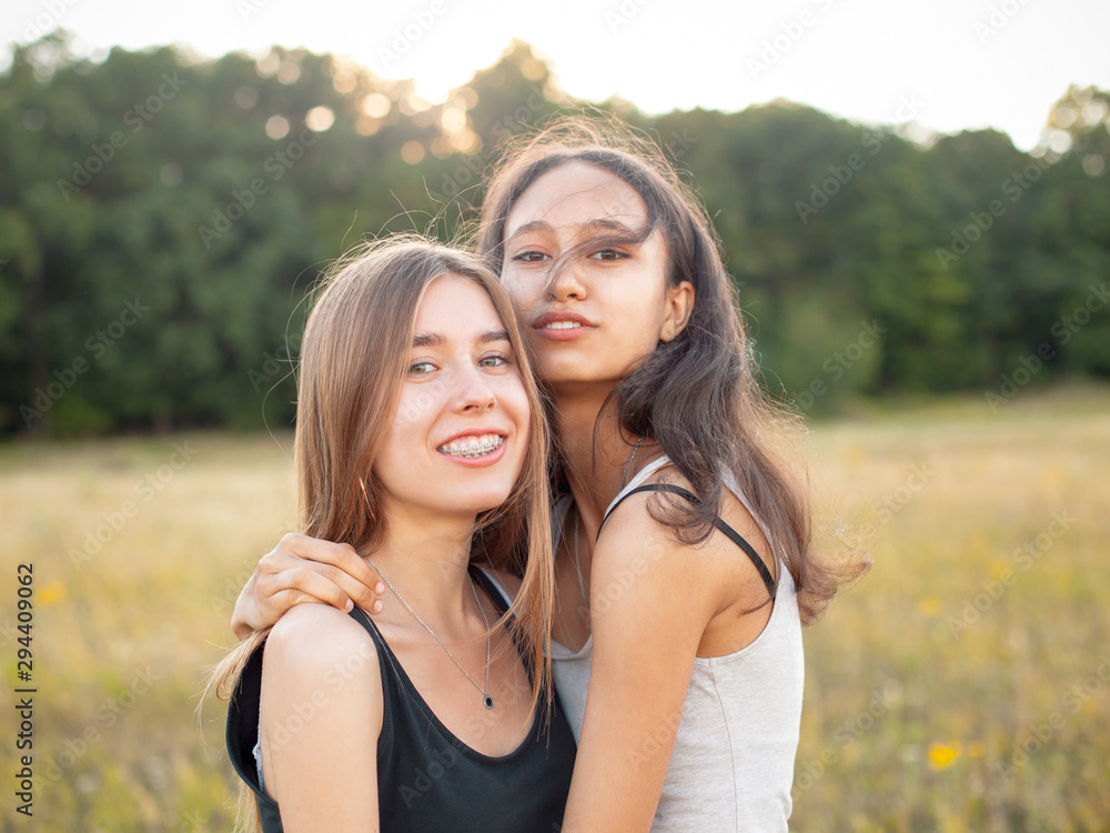 Two adorable young women hugging on the field. Best friends Two adorable young women hugging on the field. Best friends