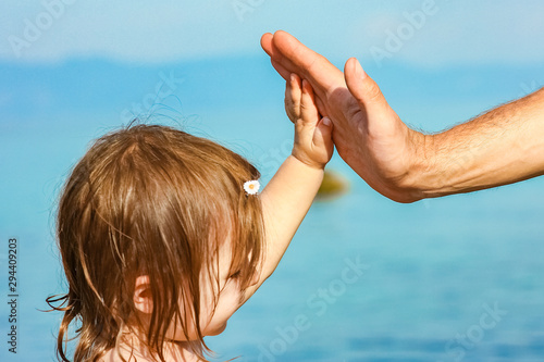 beautiful hands of parent and child by the sea