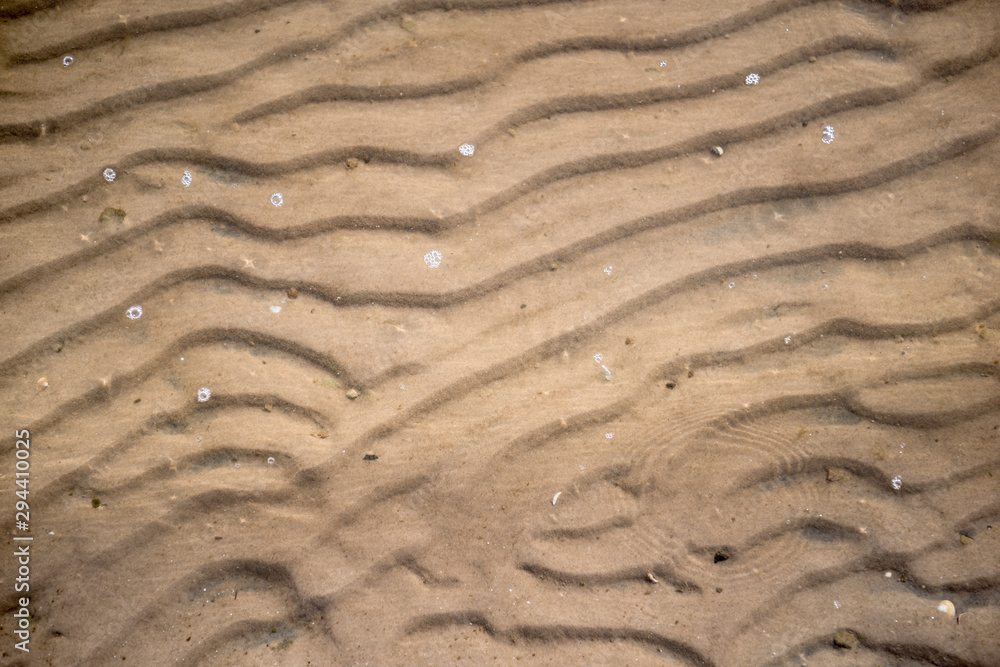 Fototapeta premium Ripples in wet sand background texture