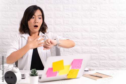 Shocked woman holding hand with wrist watch