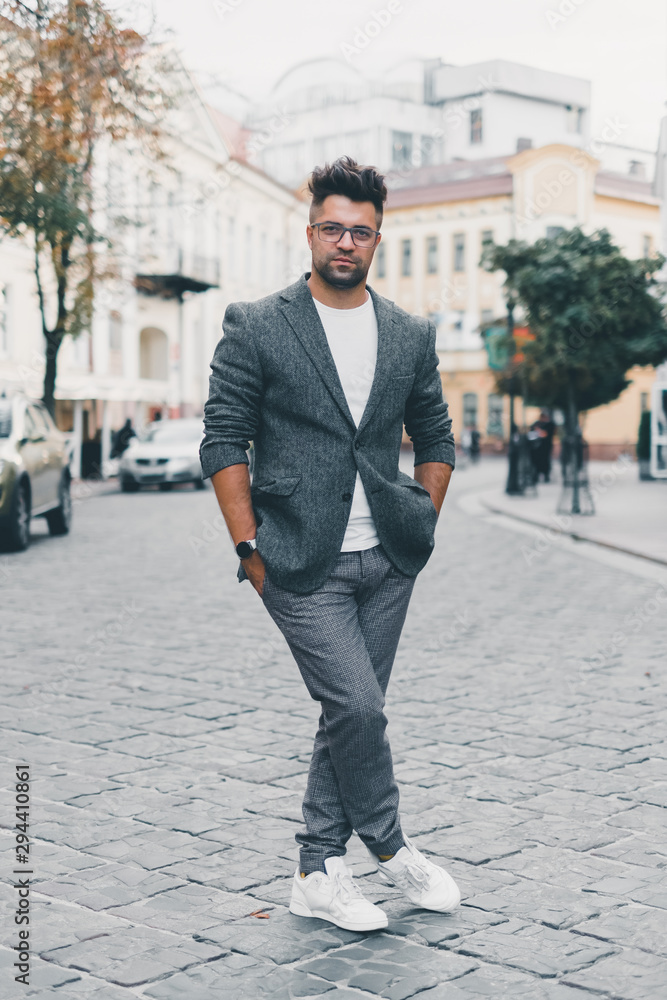 Handsome beard man posing in the street, hipster style, outdoor fashion portrait,young guy with a beard and mustache with glasses in a suit posing on the street in the sunlight, Amsterdam Handsome beard man posing in the street, hipster style, outdoor fashion portrait,young guy with a beard and mustache with glasses in a suit posing on the street in the sunlight, Amsterdam