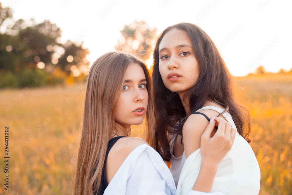 Portrait of two young women outdoors at sunset. Best friends
