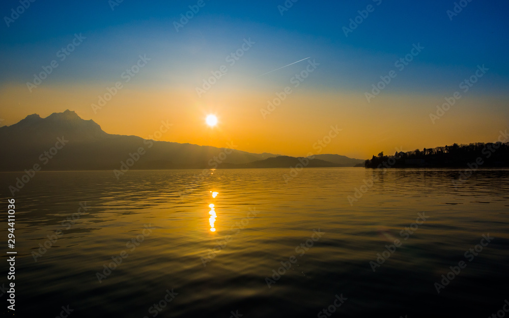 Fototapeta premium Sun reflection while setting over a lake