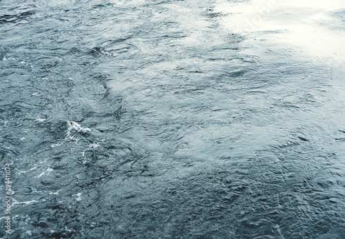 Water surface with ripples and sunlight reflections