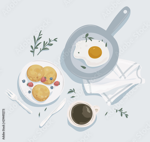 Breakfast top view. Cup of coffee, crepes, and fried eggs in a pan.
