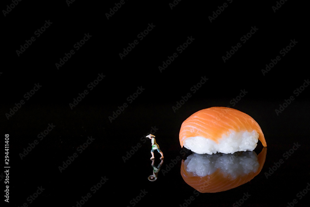 Nigiri Sushi on black acrylic glass with reflection and miniature rice farmer Nigiri Sushi on black acrylic glass with reflection and miniature rice farmer