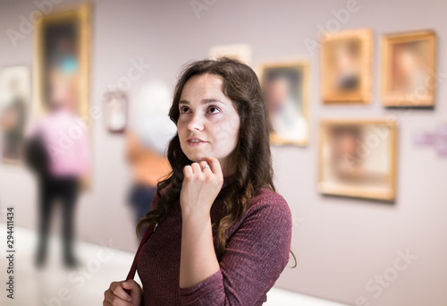 Adult girl watching at art collection exhibition