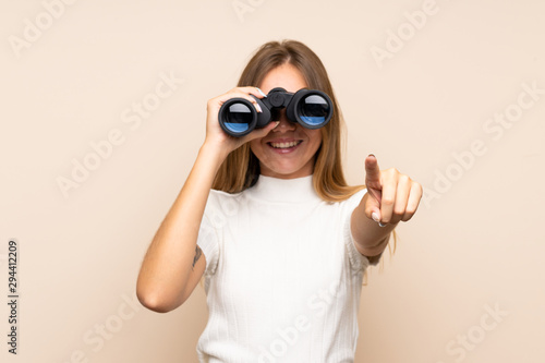 Cuadro en lienzo Young blonde woman over isolated background with black binoculars