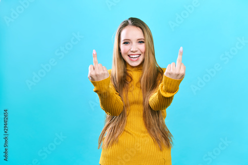 Принти на полотні Young beautiful woman standing over isolated blue background Showing middle fing