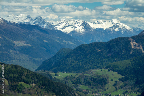 Beautiful aerial view of high snow-covered mountains and valley with village in Switzerland © Kokhanchikov