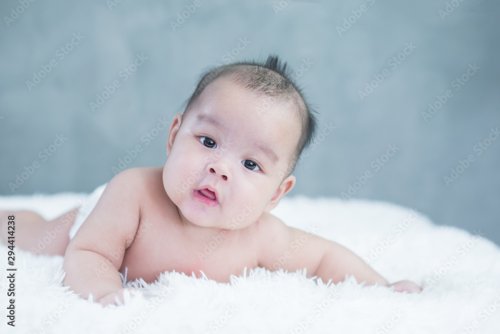 Happy Asian baby lying on white background with copy space Happy Asian baby lying on white background with copy space
