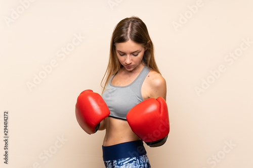 Young blonde sport girl over isolated background with boxing gloves © luismolinero