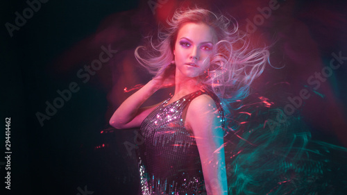 Attractive dancing blonde in the club, neon light, motion effects