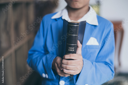 Little Asian boy pray with bible in classroom at school, bible study concept