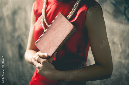 Vitnage Chinese woman in red is holding a blank cover book for mock up photo